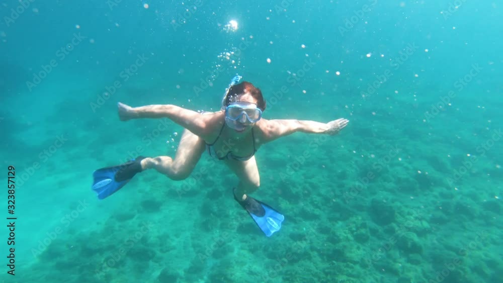 Underwater view of girl in bikini snorkeling in crystal clear sea water Underwater view of girl in bikini snorkeling in crystal clear sea water