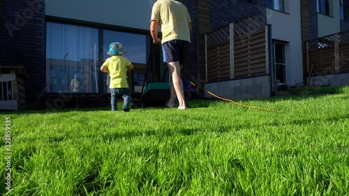 Family boys father and son cut mow lawn grass in private yard. Gimbal movement
