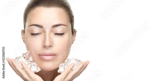 Beauty Skin care Treatments. Spa Woman with healthy clean skin aplying ice cubes on face. photo