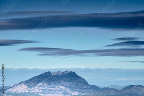 Granite mountain with blue atmosphere and big clouds, Montserrat, Catalonia