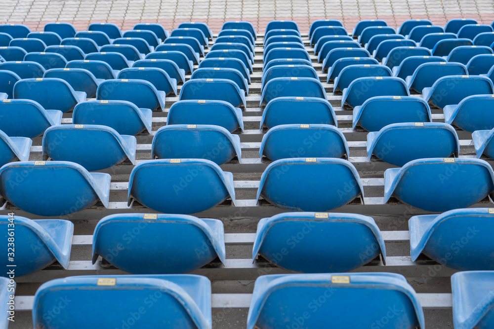 Seats in the stadium are in the background. auditorium-stands. Rows of chairs in an open-air stadium. Spectator seats. Seats in the stadium are in the background. auditorium-stands. Rows of chairs in an open-air stadium. Spectator seats.