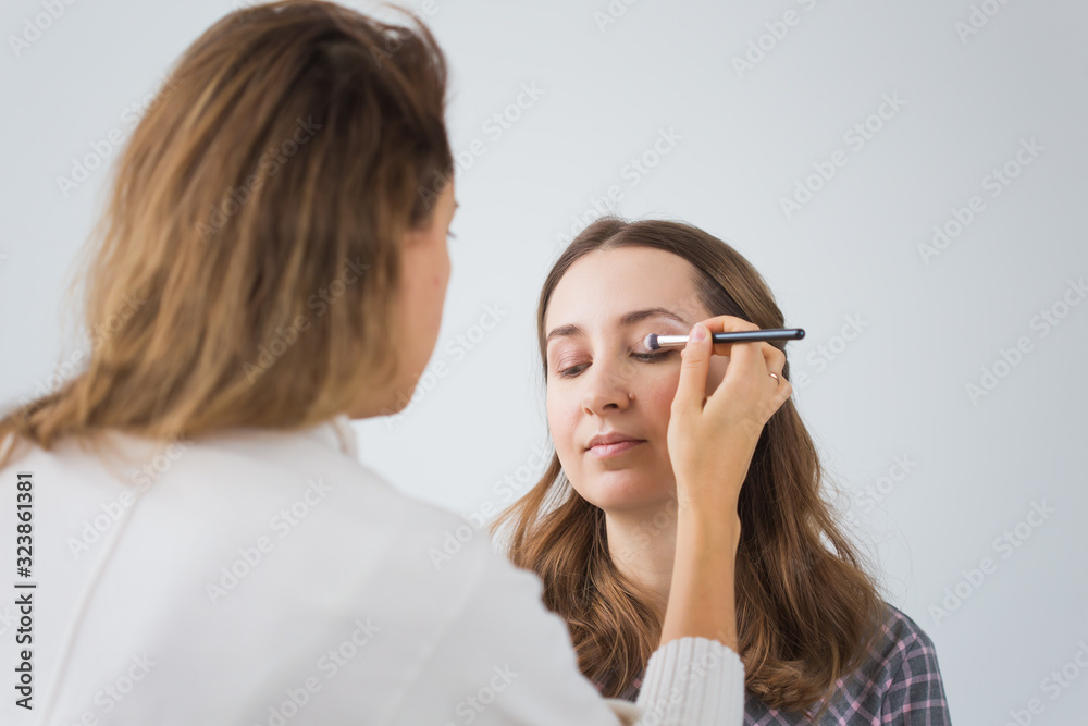 Beauty and cosmetics concept - Makeup artist doing professional make up of young woman Beauty and cosmetics concept - Makeup artist doing professional make up of young woman