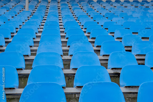 Seats in the stadium are in the background. auditorium-stands. Rows of chairs in an open-air stadium. Spectator seats.