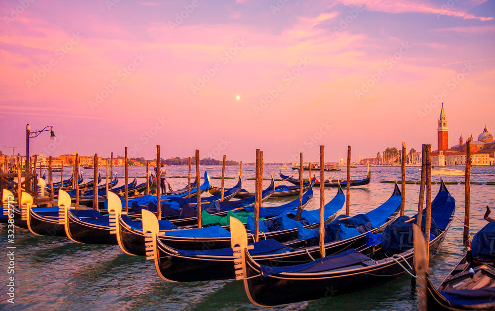 Gondolas in Venice Grand Canal at sunset, Italy. Architecture and landmarks of Venice.