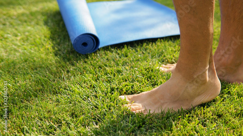 Man is going yoga practice outdoors on a sunny meadow. Yoga legs concept