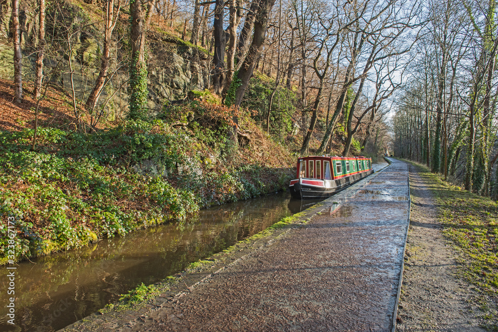 Narrowboat on a British canal in rural setting Narrowboat on a British canal in rural setting
