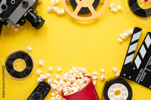 Flat lay arrangement of cinema elements on yellow background with copy space photo