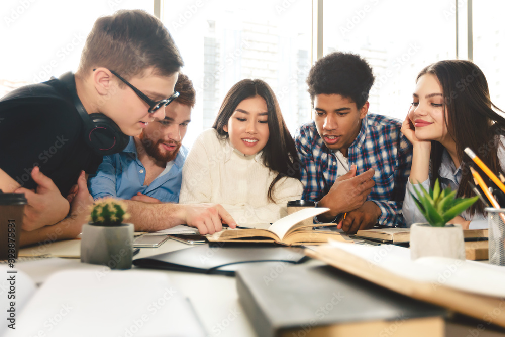 Preparing for exams together. Students studying in library Preparing for exams together. Students studying in library