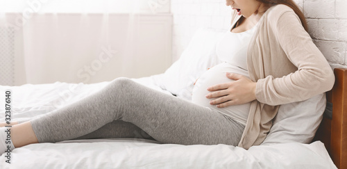Tableau sur toile Pregnant woman suffering from contractions at home