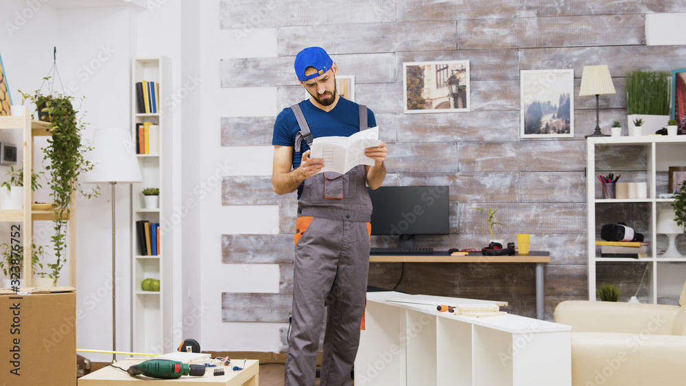 Confused furniture assembly worker while reading instructions Confused furniture assembly worker while reading instructions