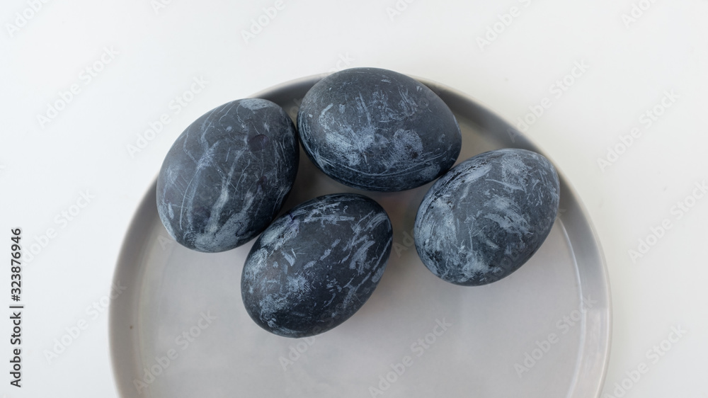 Naturally dyed blue eggs prepared for Easter on white background. Happy Easter card. Easter background with Easter eggs in a ceramic gray bowl. Background with easter eggs. Top view Naturally dyed blue eggs prepared for Easter on white background. Happy Easter card. Easter background with Easter eggs in a ceramic gray bowl. Background with easter eggs. Top view