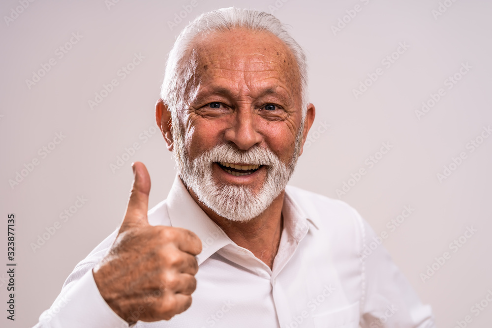 Portrait of cheerful senior man who is showing thumb up. Portrait of cheerful senior man who is showing thumb up.