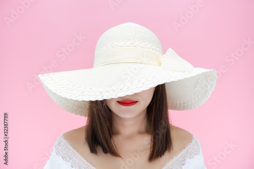 Girl with white sun hat smiling on red lipstick on pink background