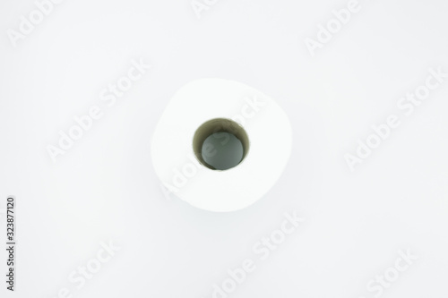 A white row of toilet paper with brown paper core lay flat on white background. Close up, top view with copy space.