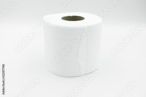 A white row of toilet paper with brown paper core lay on white background. Close up, side view with copy space.