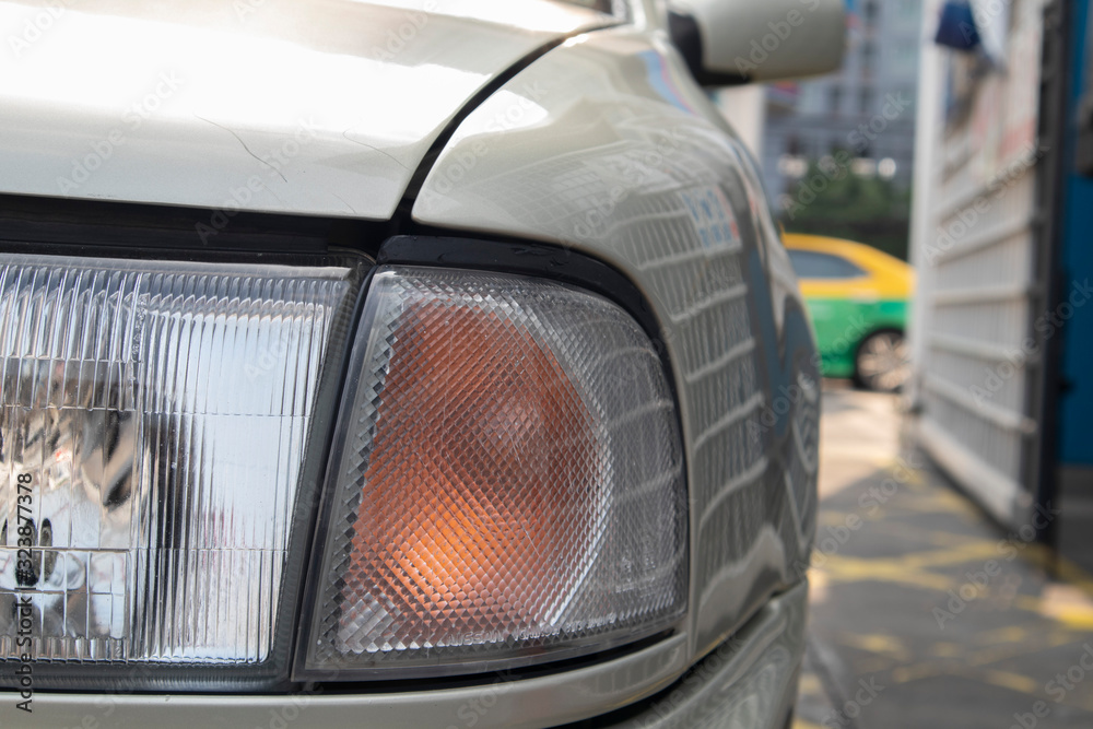 The orange turning signal like a honeycomb with nectar inside near front lamp of the car.  being washed in a car care