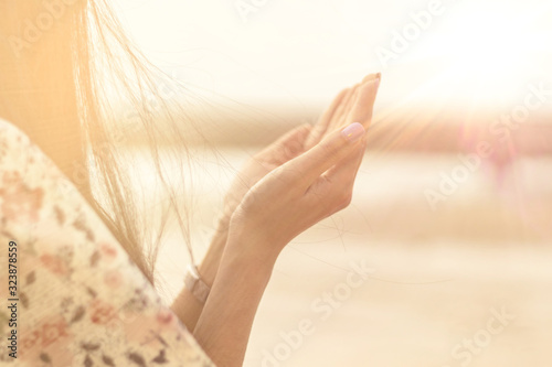Fotografija A woman praying hand for blessings When the sun goes down Hope for a happy life