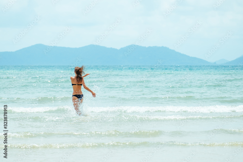Happy carefree woman wearing bikini having fun on summer vacation