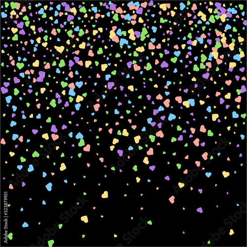 Background from bright multi-colored confetti. Festive heart shaped confetti. Joyful confetti on a black background. Bright colorful background.