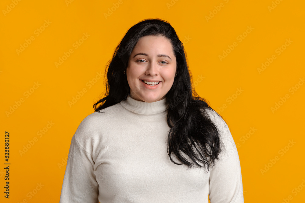 Portrait of happy millennial plump woman smiling at camera Portrait of happy millennial plump woman smiling at camera