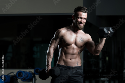 Bodybuilder Exercising Biceps With Dumbbells