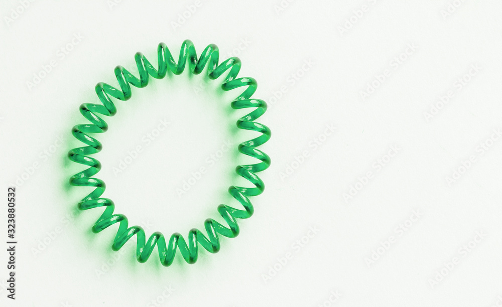 Green spiral rubber band. Elastic hair tie on white background close-up, copy space Green spiral rubber band. Elastic hair tie on white background close-up, copy space
