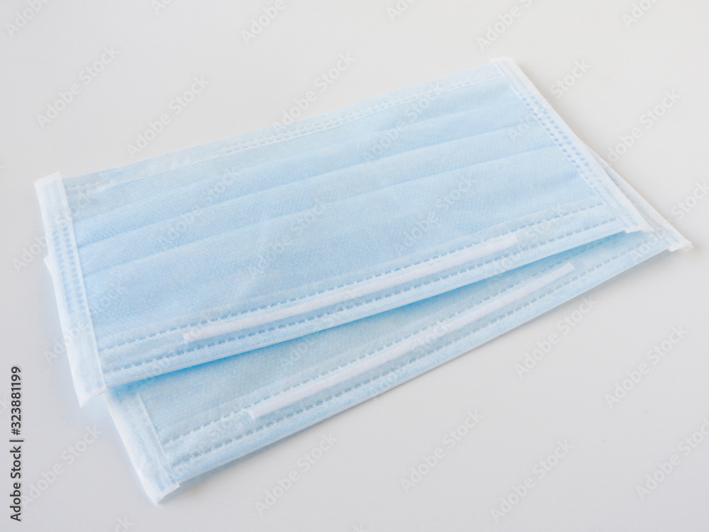 High angle view of blue disposable surgical mask isolated on white background. Novel coronavirus (COVID-19). Health and medical concept.Two pieces . Face mask. In Taiwan,limit purchase quantity. High angle view of blue disposable surgical mask isolated on white background. Novel coronavirus (COVID-19). Health and medical concept.Two pieces . Face mask. In Taiwan,limit purchase quantity.