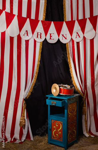 Circus backstage in retro style, drum on aa pedestal. Red stripped curtain background with various circus objects. Circus Theater stage. Old circus arena interior