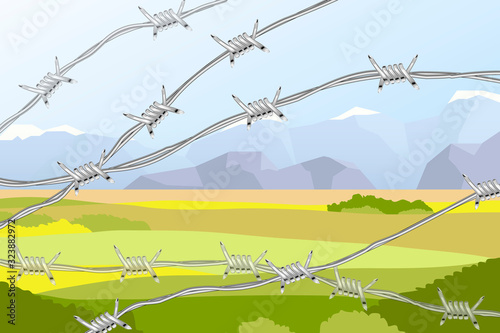 Several lines of realistic barbed wire on landscape with fields and mountains