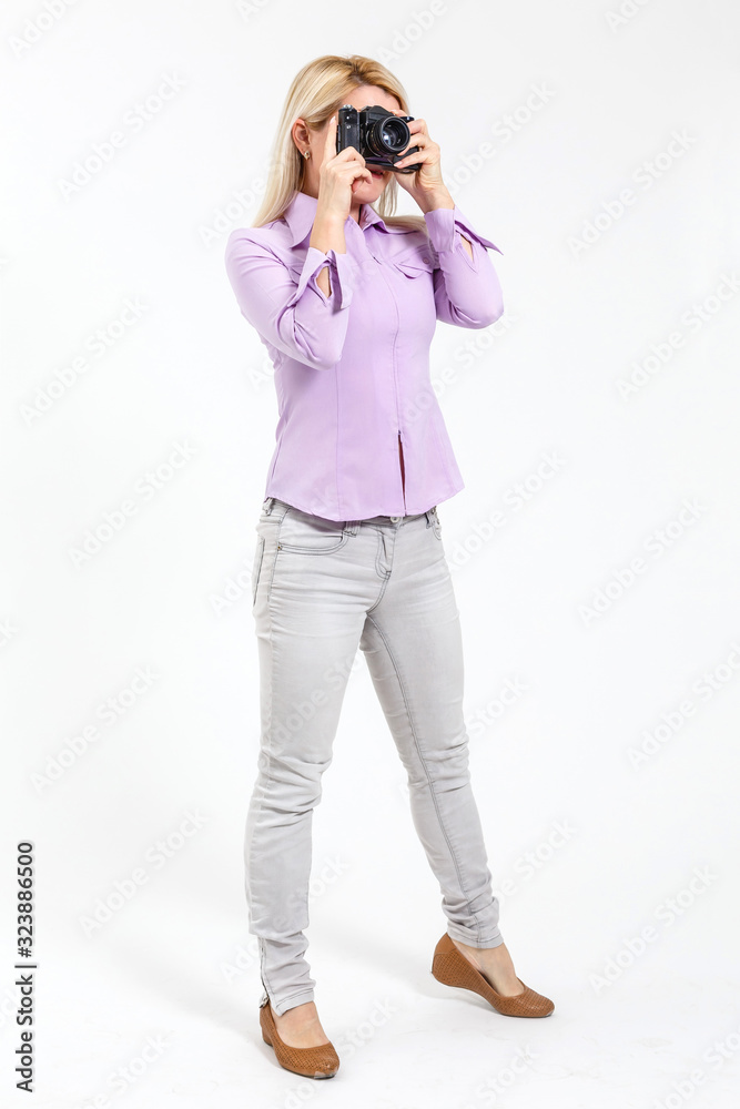 Young beautiful smiling blond woman holding a micro four thirds photo camera. Isolated over white background. Young beautiful smiling blond woman holding a micro four thirds photo camera. Isolated over white background.