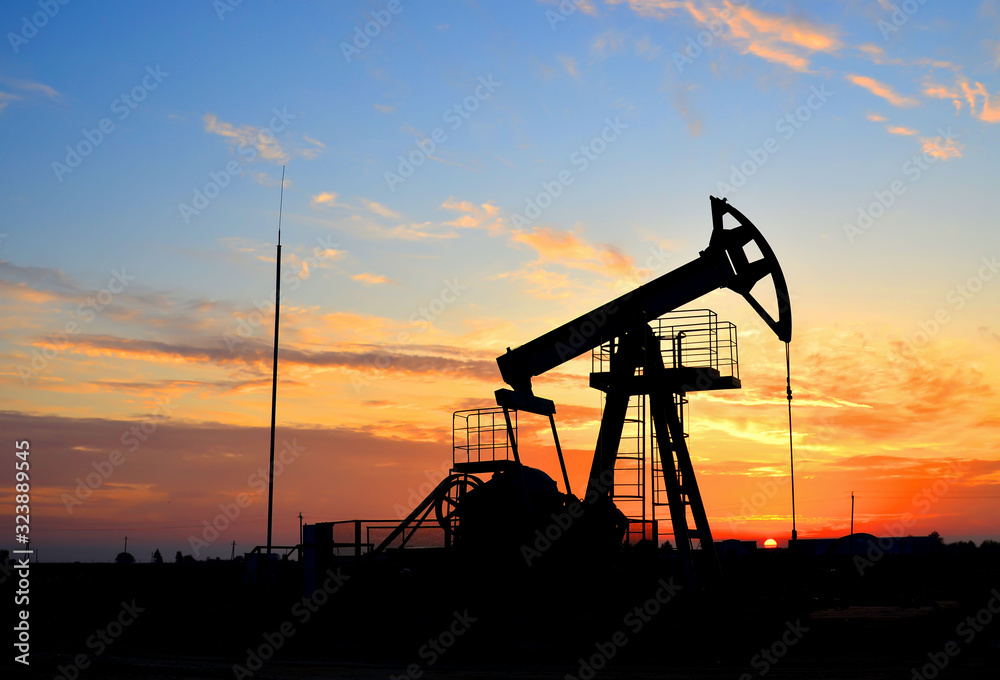 Oil drilling derricks at desert oilfield for fossil fuels output and crude oil production from the ground. Oil drill rig and pump jack.