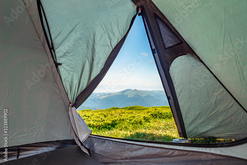 View from the tourist tent on the mountains, meadow, early in the morning when the sun rises. tourist tent