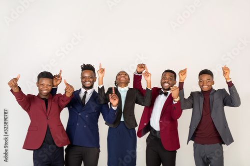 team of young handsome african men and women in suits on a white background with hand gesture