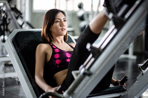 Young healthy woman doing leg presses in the gym