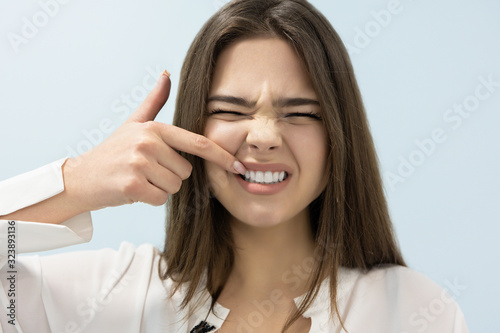 young beautiful blond woman standing on isolated white background suffering from sudden gum pain, touching her tooth, healthcare and medical