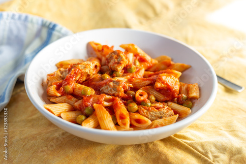 Penne pasta with tomatoes sauce and chicken. Italian traditional dish