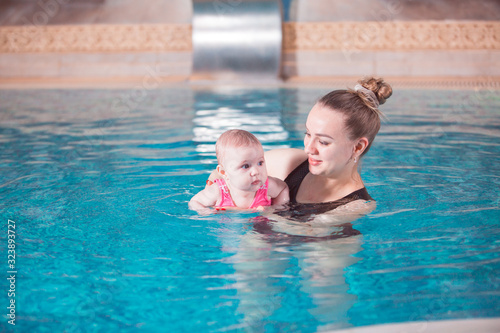 young mother teaches her child to swim