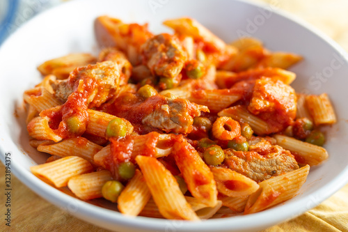 Penne pasta with tomatoes sauce and chicken. Italian traditional dish