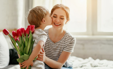 happy mother's day! child son gives flowers for  mother on holiday .