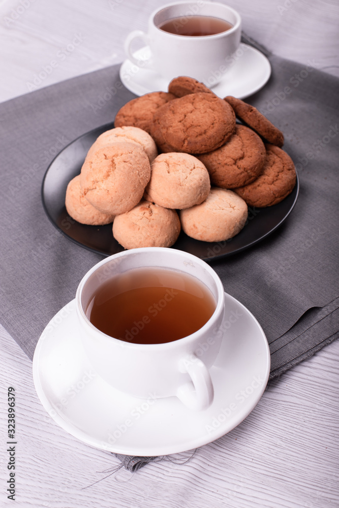 Cups of black tea with biscuits