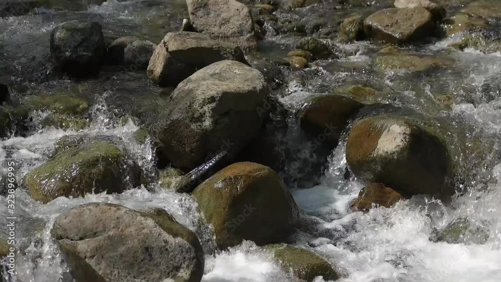 Waterfall river with big stones close up. Water splashing with foam, slow motion. Waterfall river with big stones close up. Water splashing with foam, slow motion.