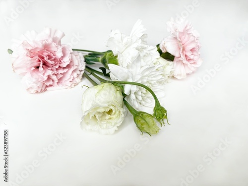 Partially blurred bouquet of white and rose flowers on a white background 