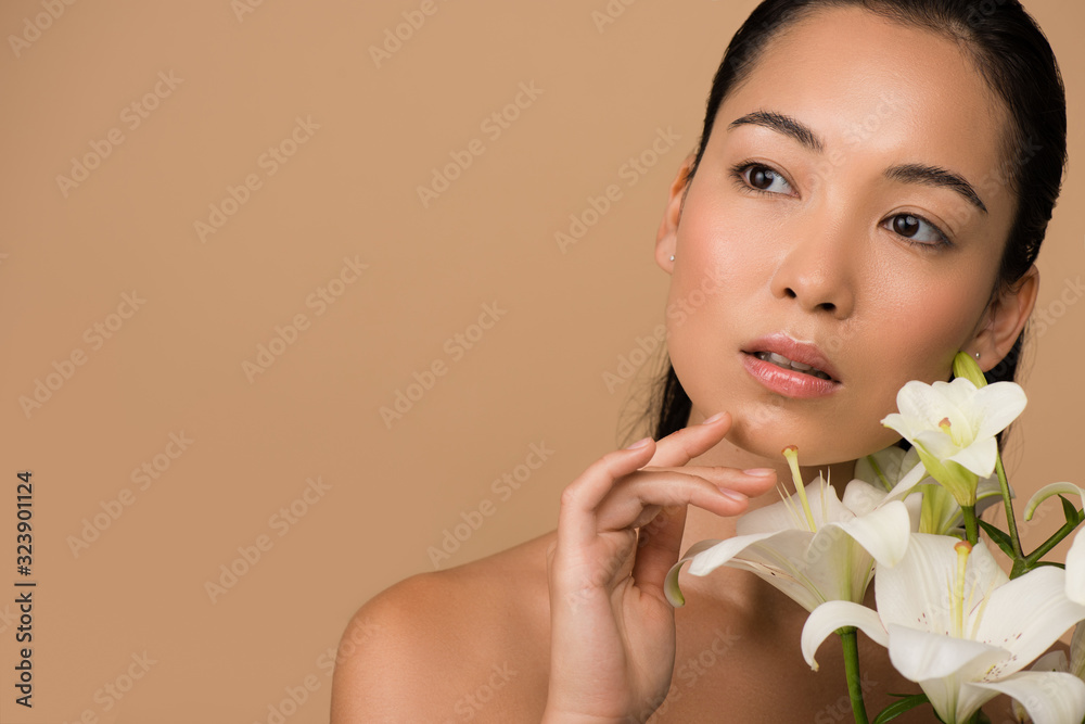 dreamy beautiful naked asian girl with white lilies isolated on beige dreamy beautiful naked asian girl with white lilies isolated on beige