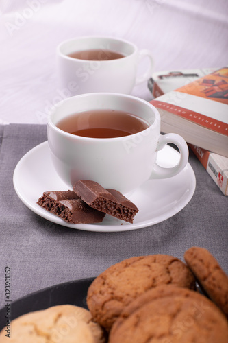 Book,sweet snack cup of tea and chocolate on the table