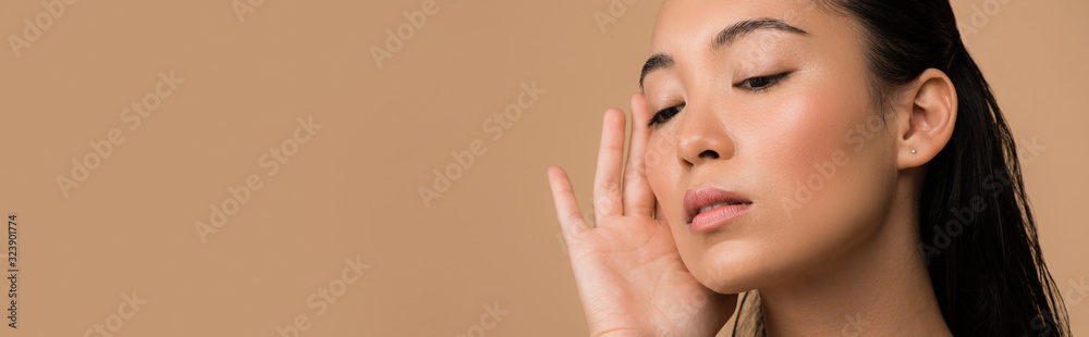 beautiful asian girl touching face isolated on beige, panoramic shot beautiful asian girl touching face isolated on beige, panoramic shot