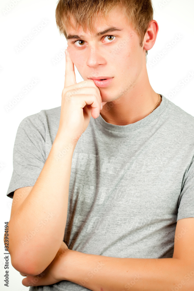 Portrait of a Caucasian young positive guy in a gray shirt and jeans posing on a gray background. Concept of a successful young student or novice employee. Advertising space Portrait of a Caucasian young positive guy in a gray shirt and jeans posing on a gray background. Concept of a successful young student or novice employee. Advertising space
