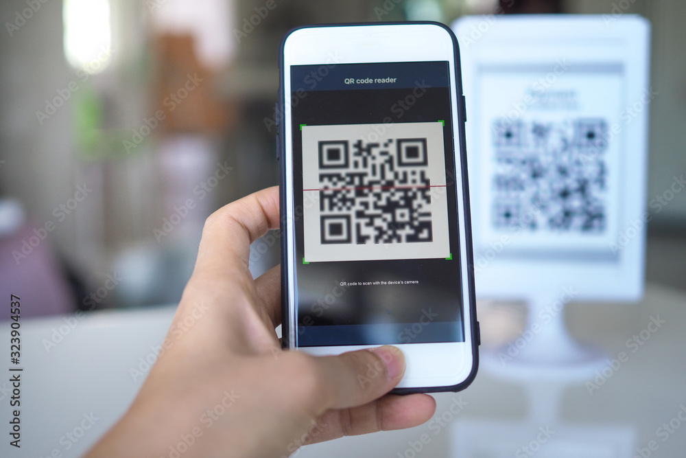 Women's hand uses a mobile phone application to scan QR codes in stores