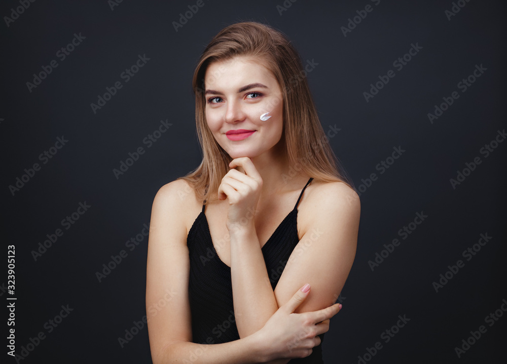 Lovely woman with smooth healthy skin applying cream on her face Lovely woman with smooth healthy skin applying cream on her face