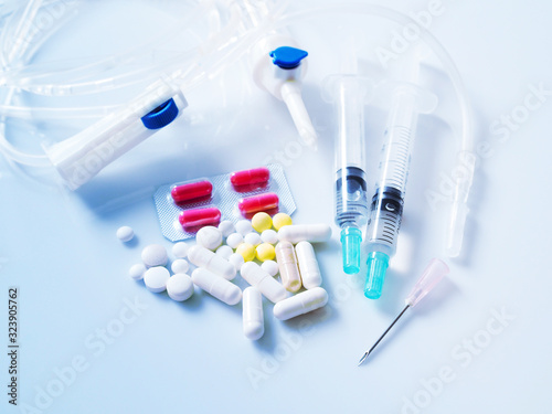 Medicine and medical equipment with painkillers, drug, capsules, needle and saline solution with syringe isolated on white background.