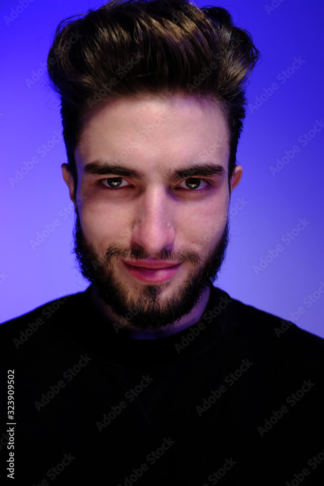 Beautiful caucasian young man portrait isolated on multicolored neon light backgroud. Young, smiling, surprised, screaming. Human emotions, facial expression concept. Trendy colors.Advertising concept